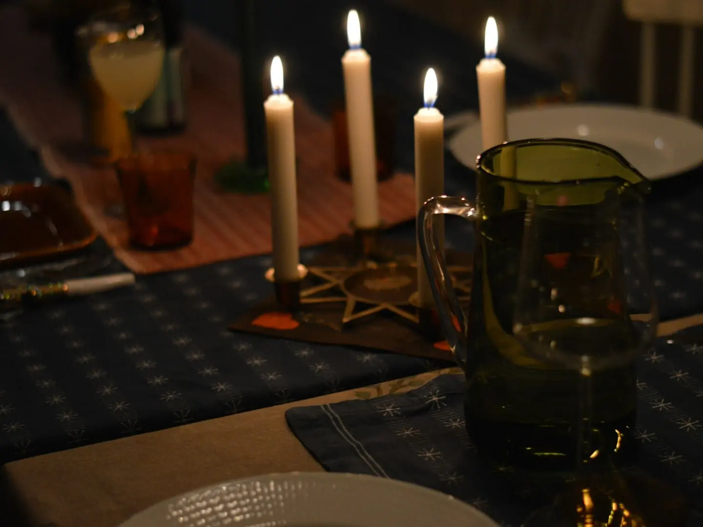 A candlelit dinner table set for an evening celebration
