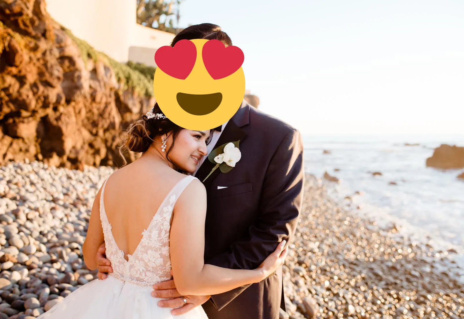 A wedding couple embracing beside coastal rocks and the ocean