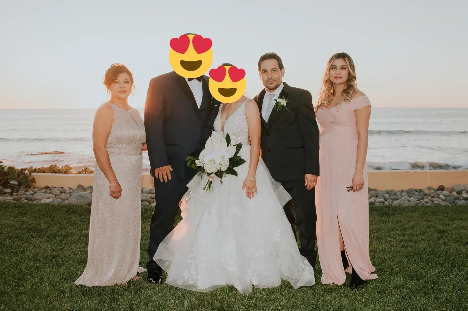 A wedding couple with three family members overlooking the ocean