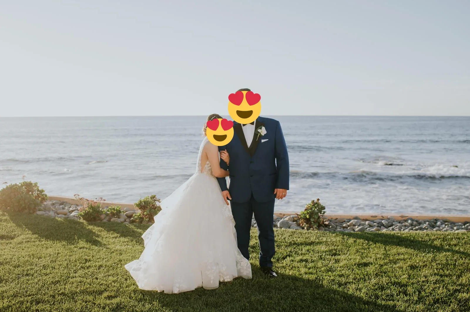 A wedding couple standing together above the ocean