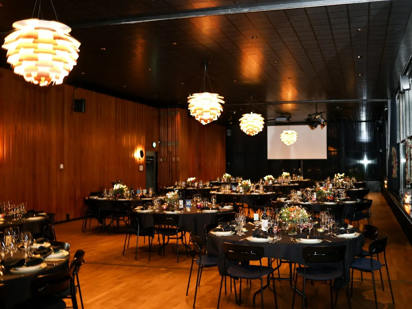 Formal event space arranged with round tables and warm lighting
