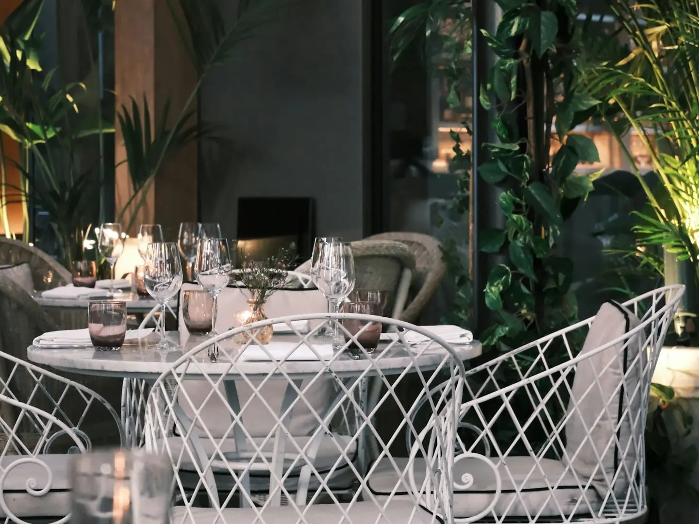 Intimate outdoor dining area set among deep green plants