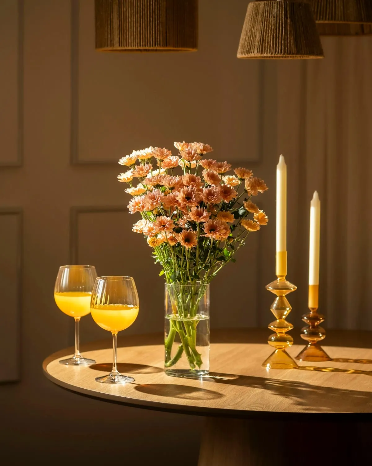 Flowers, glassware, and candlelight arranged for a dinner