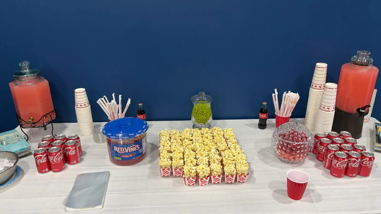 Popcorn, candy, soda, and pink drinks arranged for guests to serve themselves