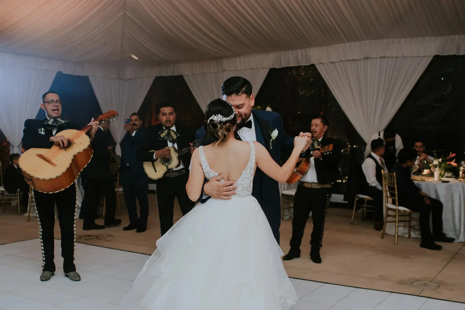 A wedding couple dancing with live musicians in the reception room